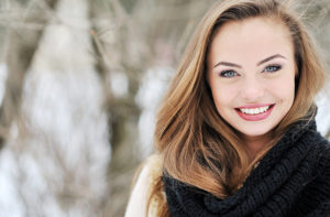 A brunette woman smiling during wintertime in the snow