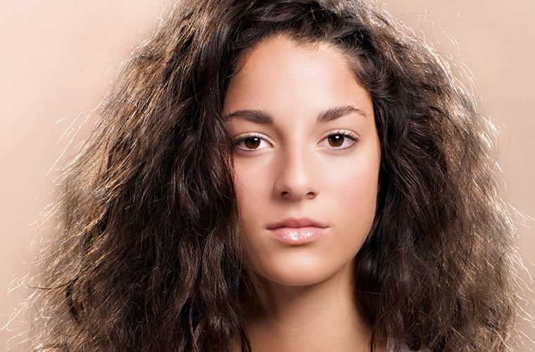 woman looking unhappy with dark and frizzy hair