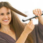 Brunette woman straightening hair