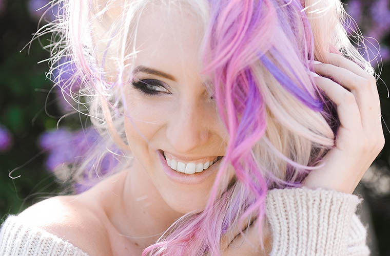 Woman with purple, pink, and blonde hair smiling
