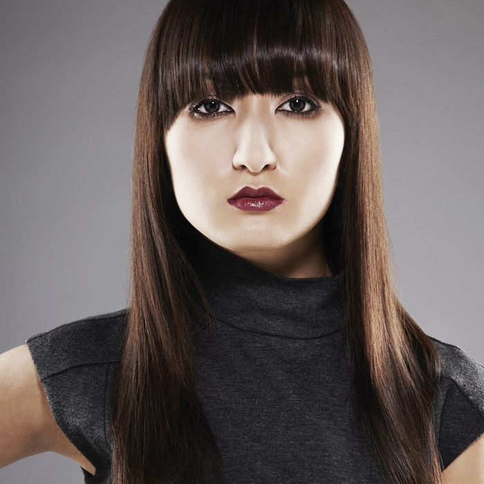 Woman with round fringe and dark hair modeling