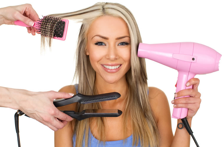 Woman using a pink blow drier, flat iron, and brush on her hair